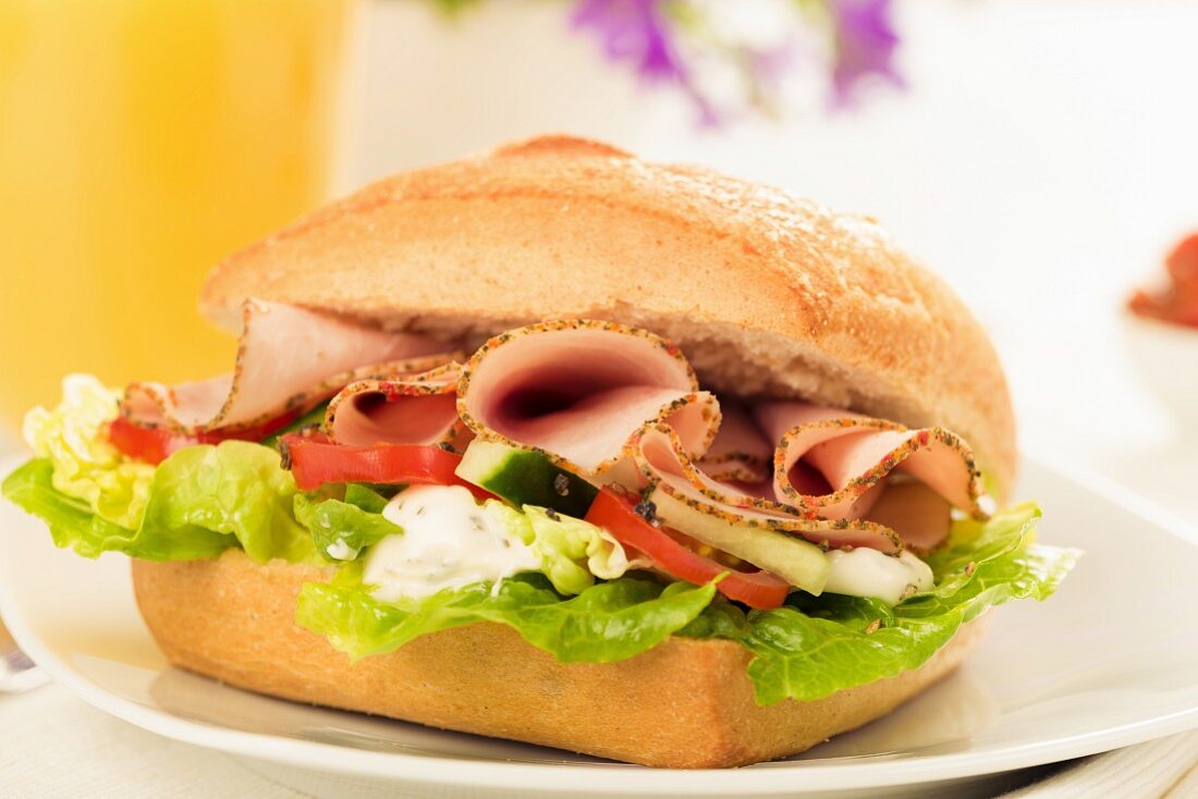 A sandwich filled with lettuce, tomatoes and sliced turkey