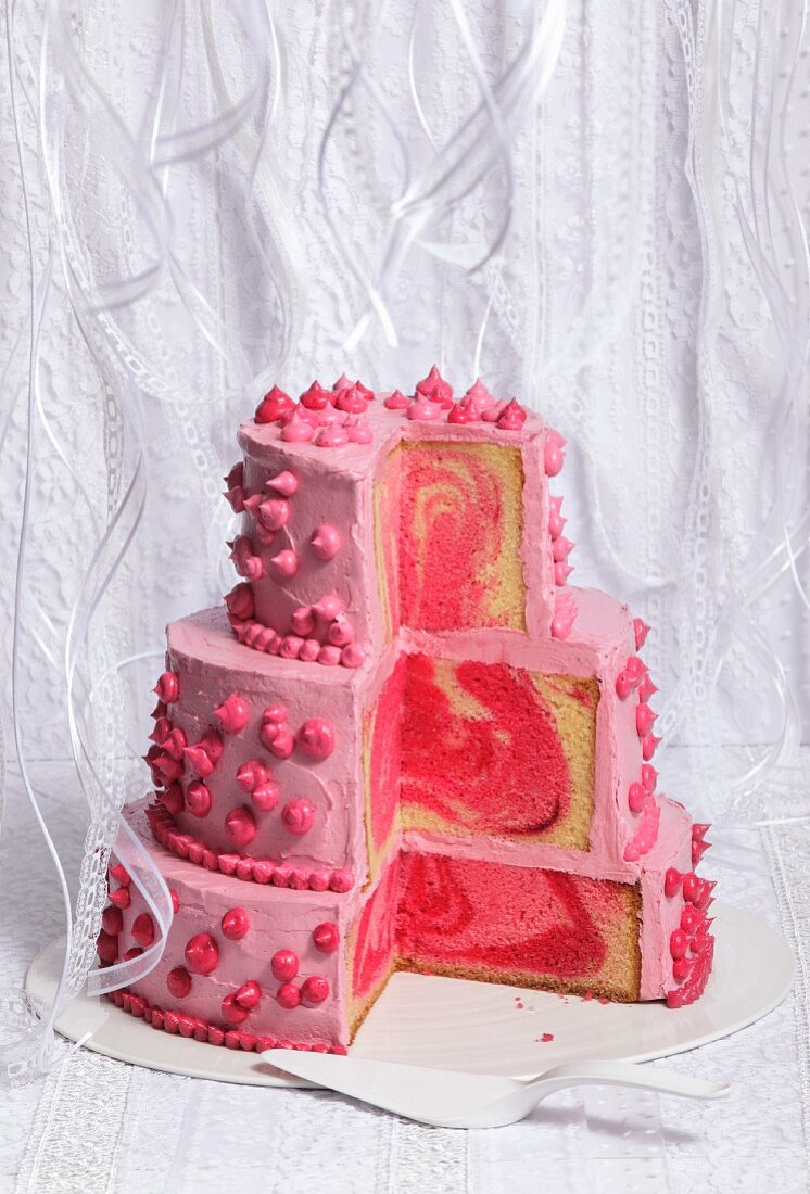 A three-tier pink wedding cake, sliced open