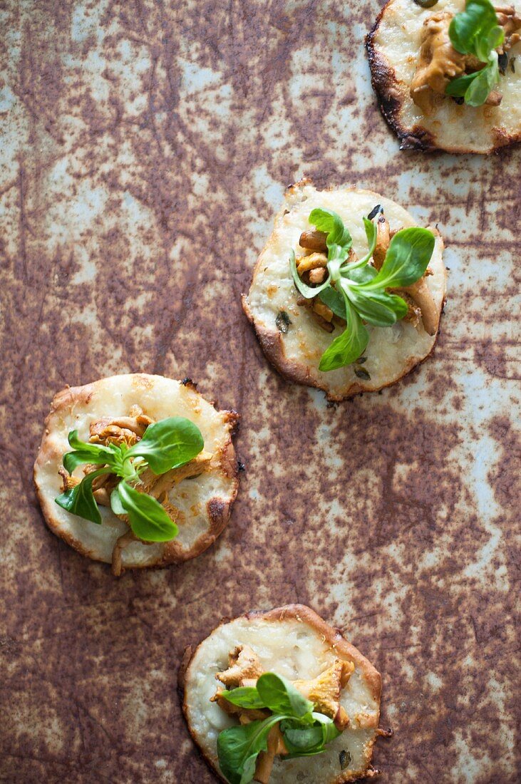 Kleine Pizzen mit Käse, Pfifferlingen und Feldsalat