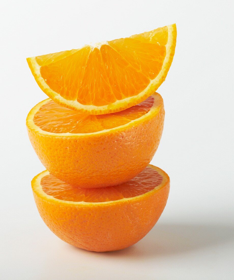 A stack of orange halves and a wedge of orange
