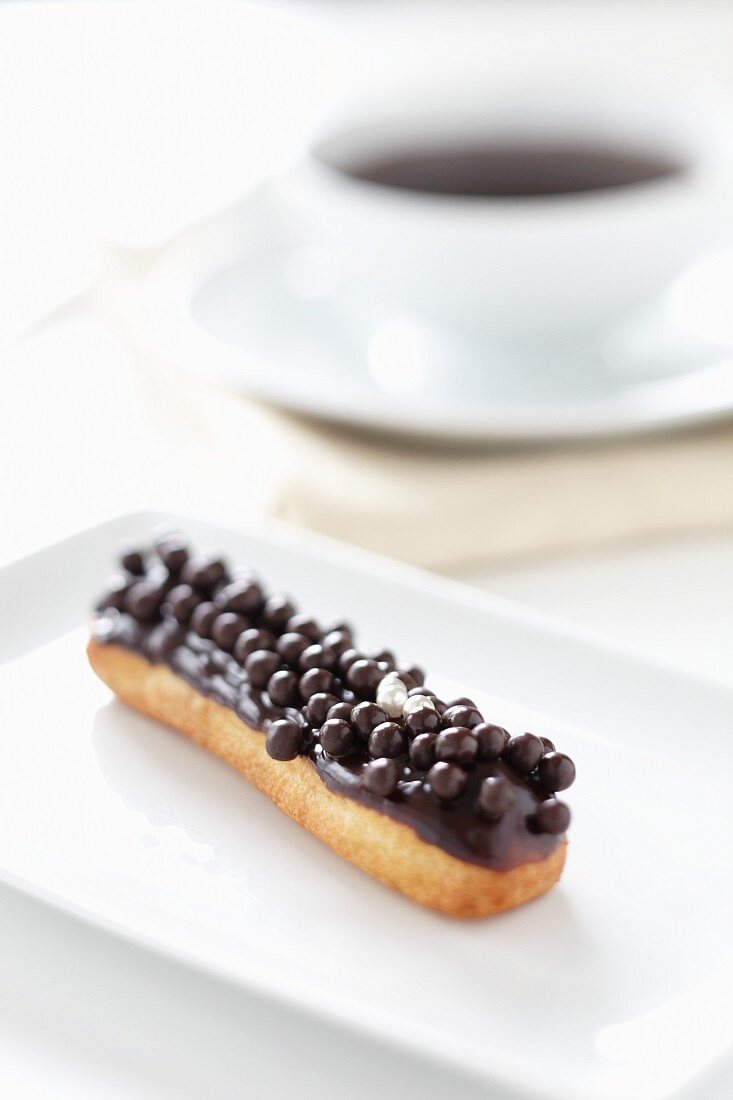 An éclair topped with chocolate balls
