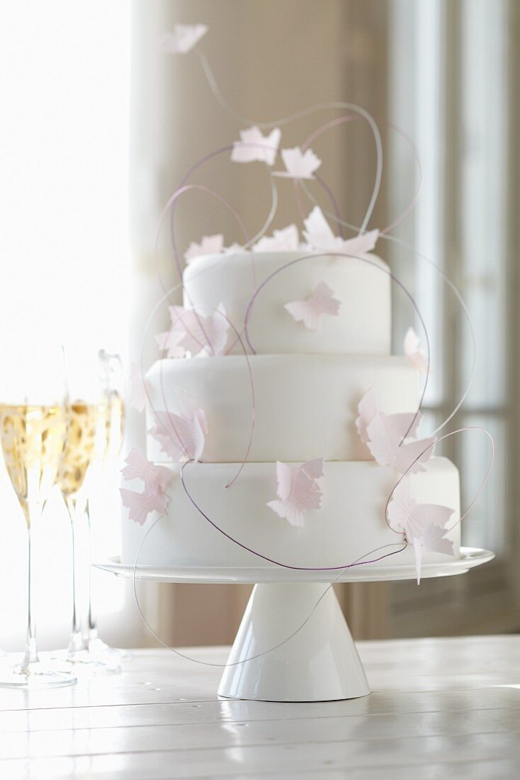 Three-tier wedding cake with paper butterflies