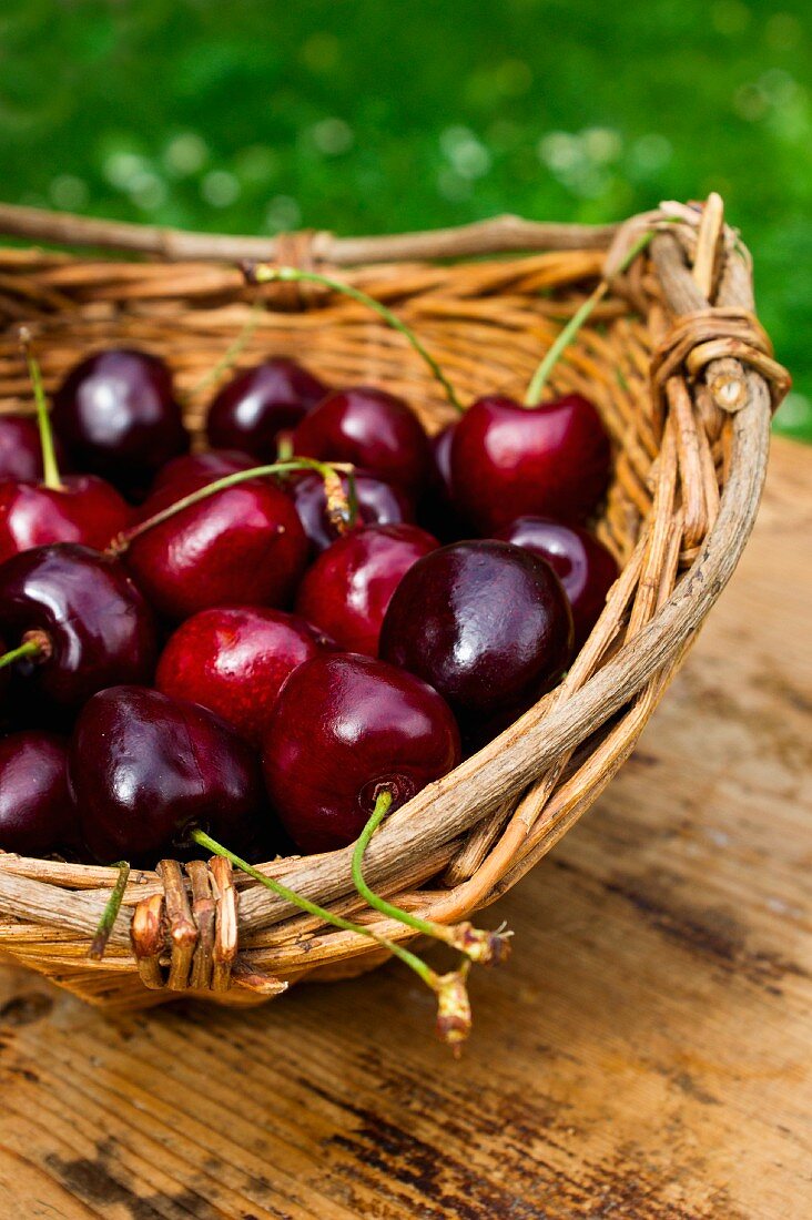 Cherries in a basket on a table outdoors