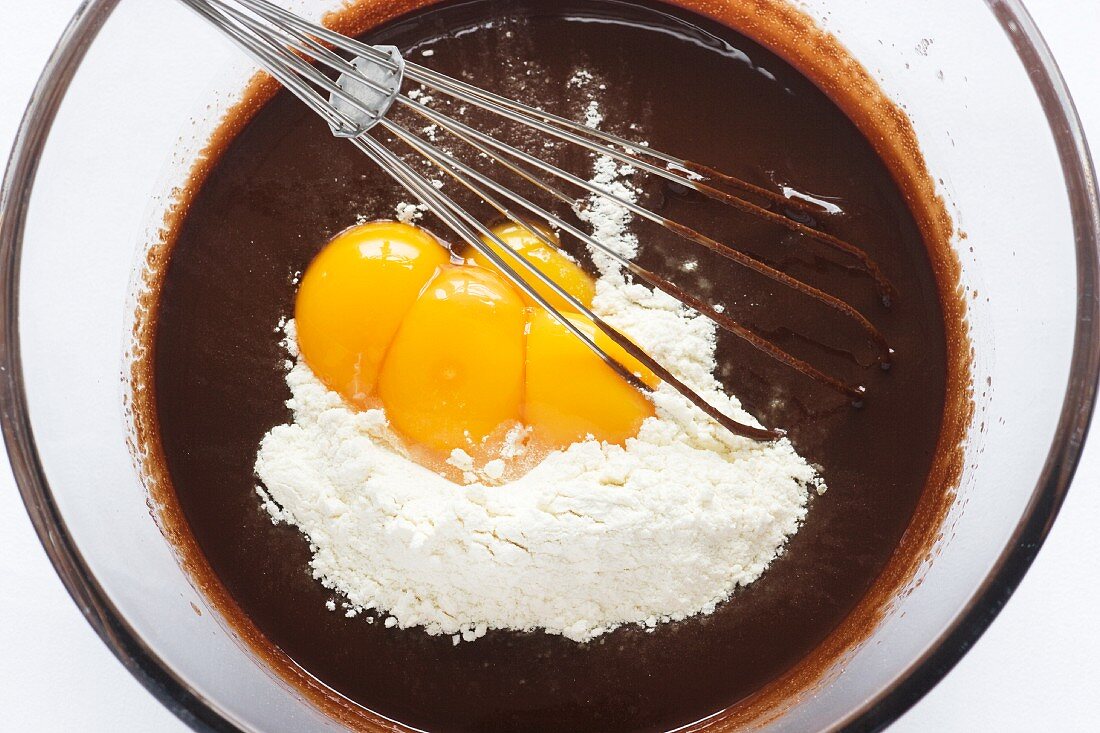In geschmolzene Schokolade Ei und Mehl unterheben