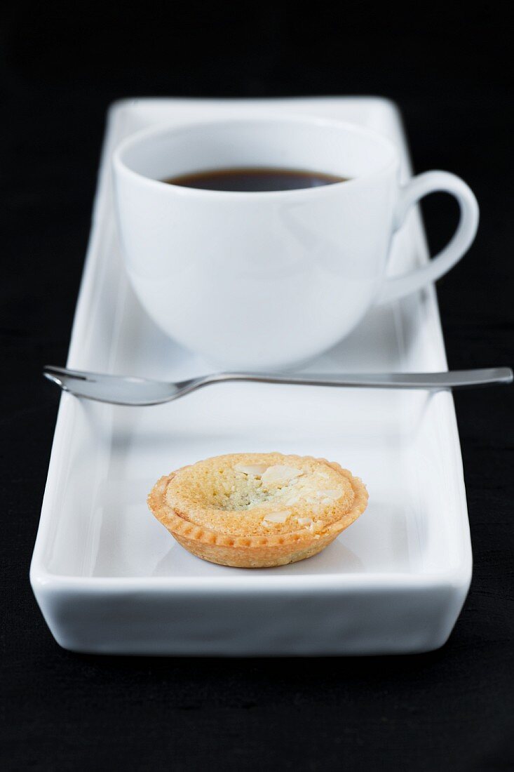 cup of coffe with small almond tart