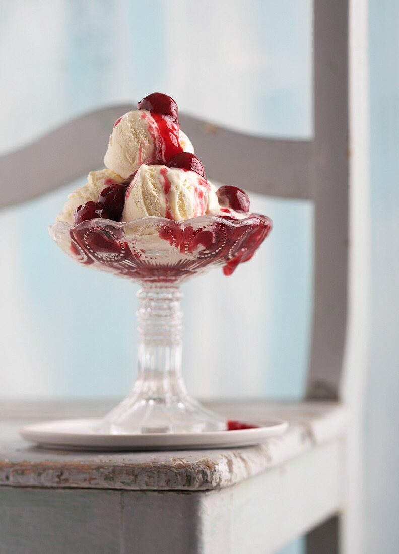 An ice cream sundae with vanilla ice cream and hot cherries