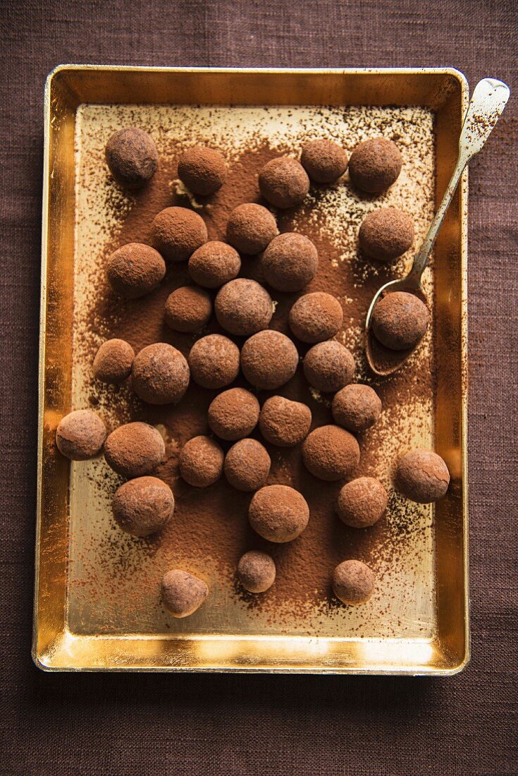 Chocolate truffles on a gold-coloured tray (view from above)