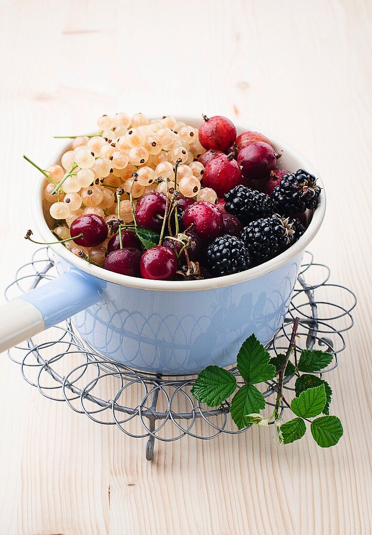 Whitecurrants, gooseberries, blackberries and cherries in an enamel pot