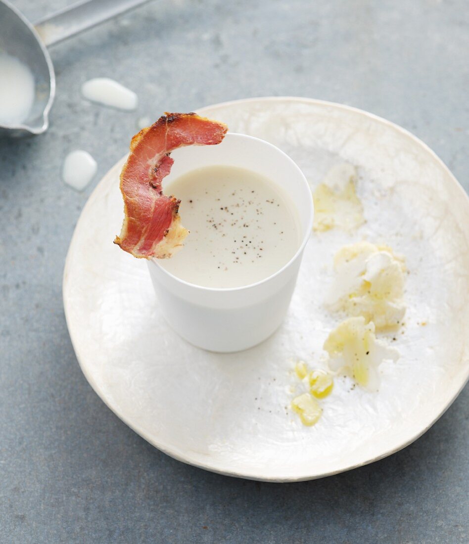 Chilled cream of cauliflower with a strip of bacon