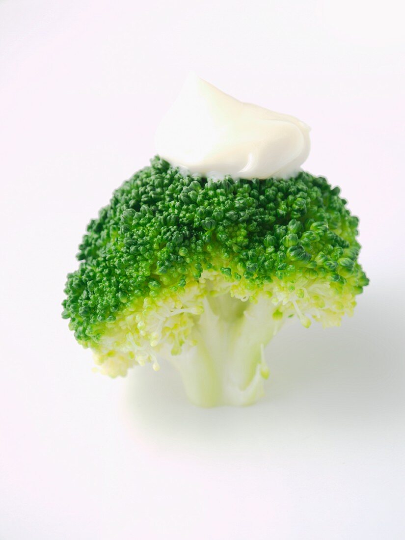 Cooked broccoli with a blob of mayonnaise