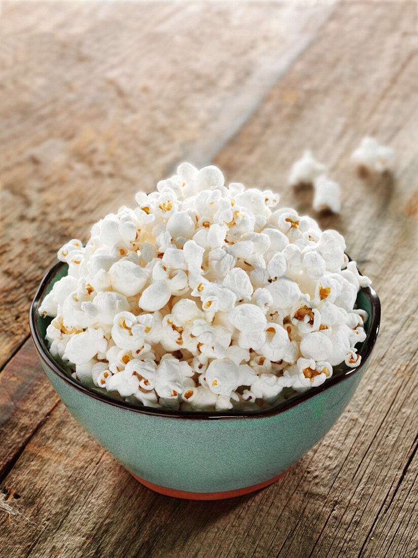 A Bowl of Plain Popcorn on a Wooden Table