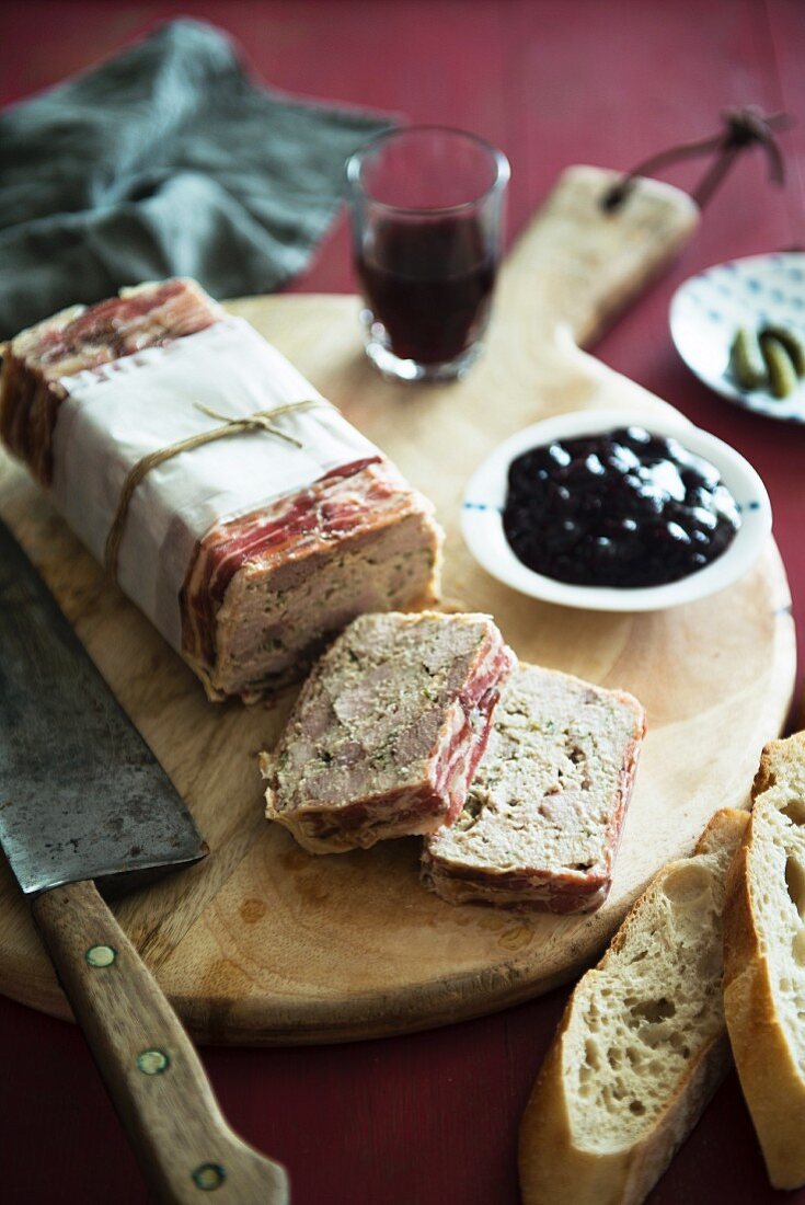 Terrine wrapped in bacon with chunks of baguette