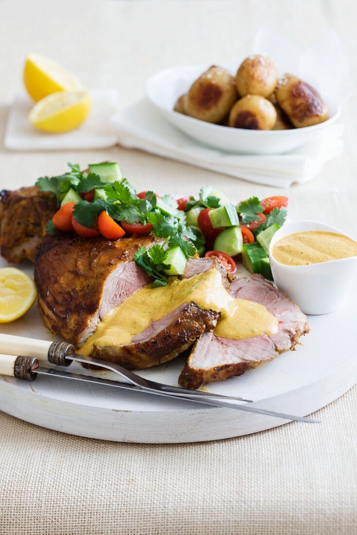 Roast lamb with curry sauce, partly sliced