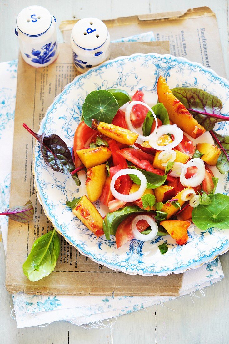 Sommerlicher Pfirsich-Tomaten-Salat mit Kapuzinerkresse und jungen Mangoldblättern