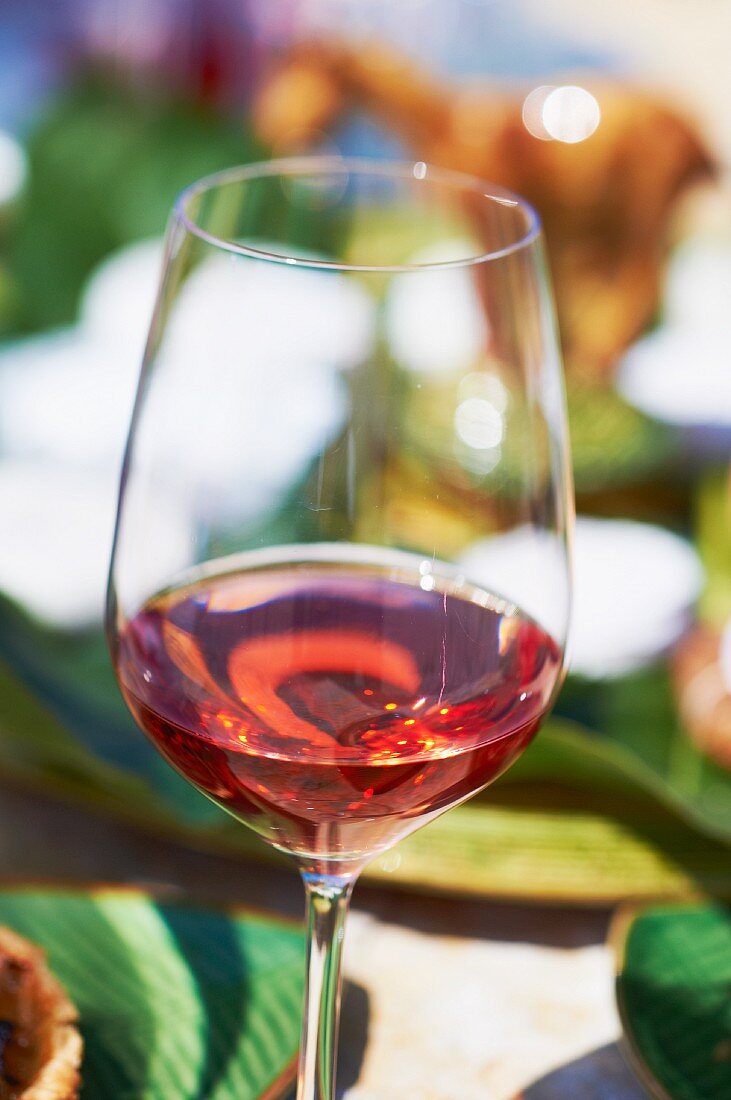 A glass of rosé wine on a sunny table (Domaine de la Begude, southern France)