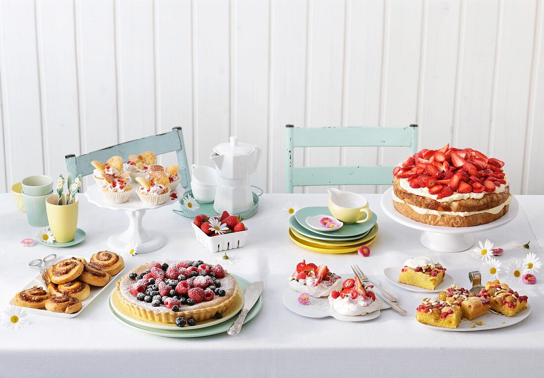 A cake buffet with berry cakes and tarts and sweet pastries