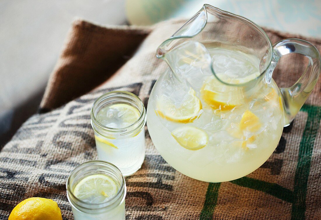 Limonade in einem Krug und Schraubgläsern