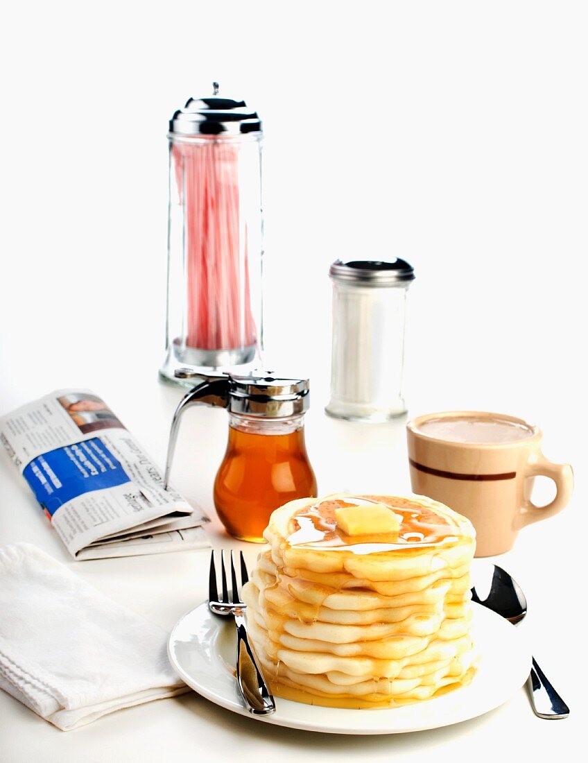 Gestapelte Pancakes mit Butter und Ahornsirup im Diner