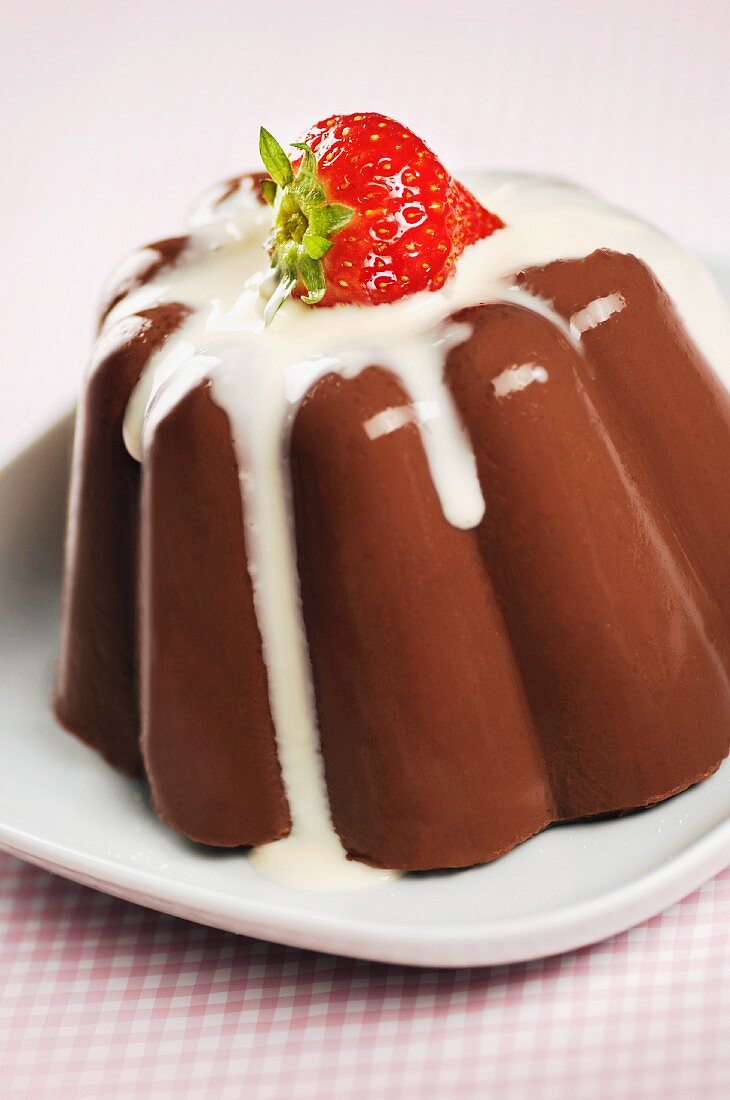 Chocolate pudding with custard and a strawberry on top