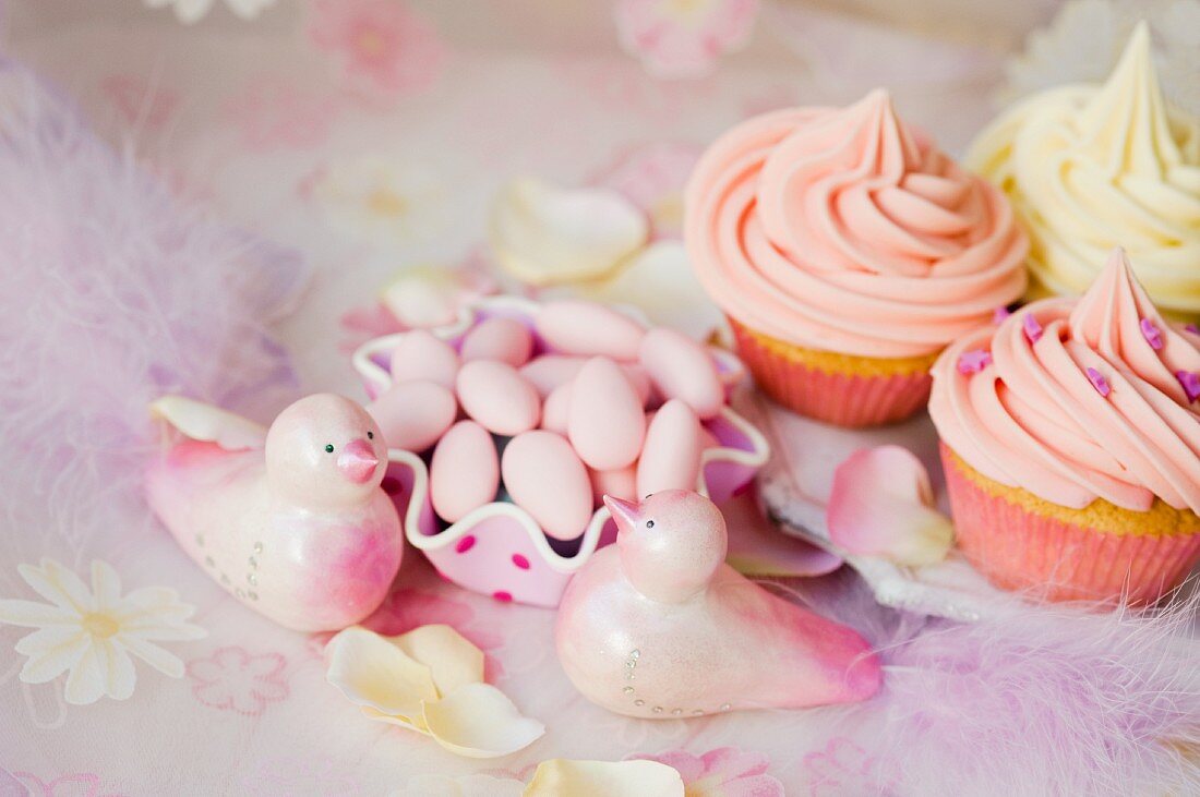Cupcakes mit Buttercreme, Zuckermandeln und rosa Dekovögel zur Hochzeit