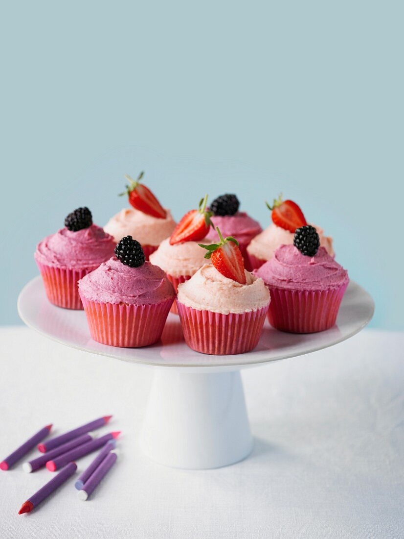 Cupcakes mit Erdbeeren und Brombeeren auf Kuchenständer