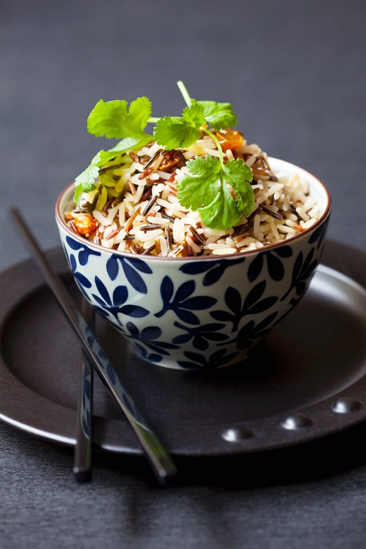Three kinds of rice with raisins and coriander in a bowl