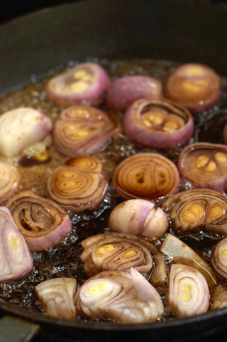Shallots being sautéed in a pan