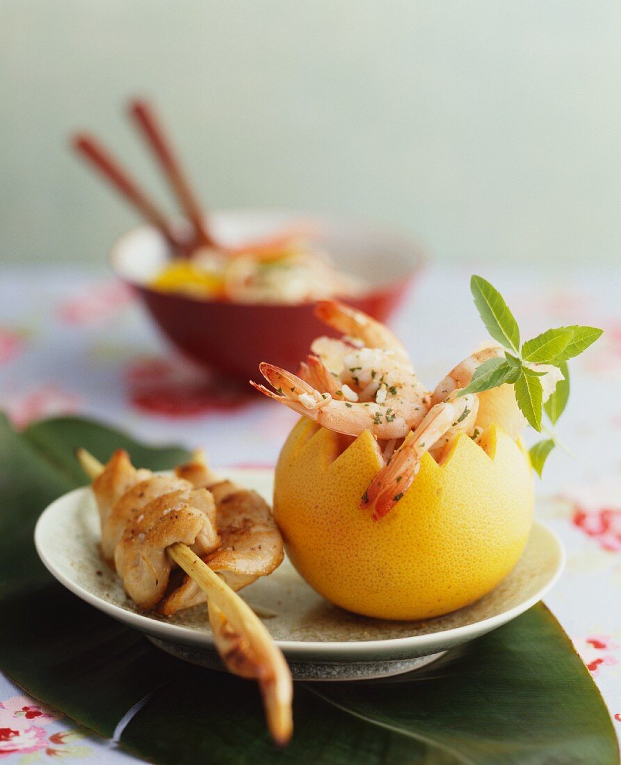 Marinated prawns in a hollowed-out grapefruit, and a satay skewer