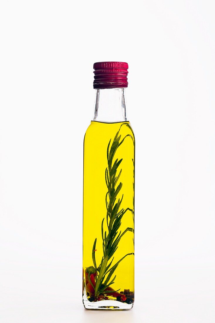 Aromatisiertes Olivenöl in der Flasche mit Rosmarin & Chili