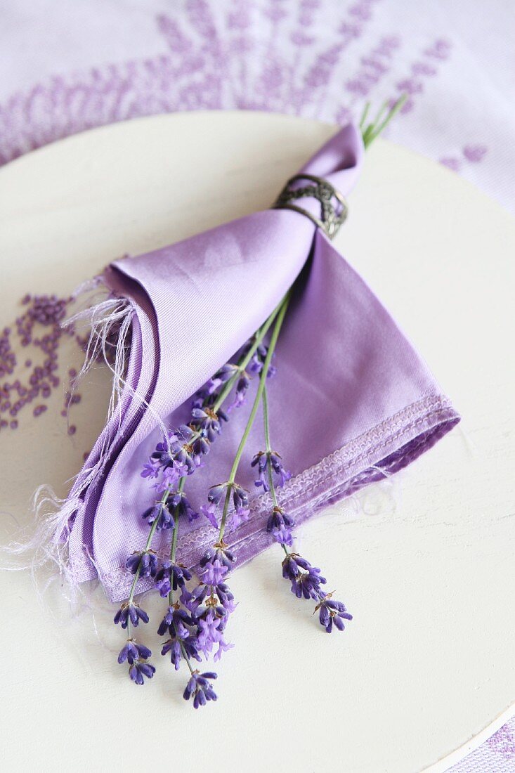 Table decoration: lavender flowers and a napkin on a plate