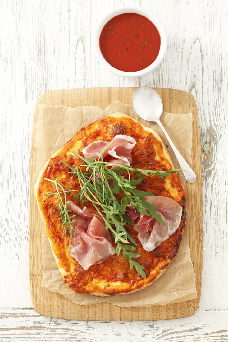 Pizza with dry-cured ham and rocket (view from above)