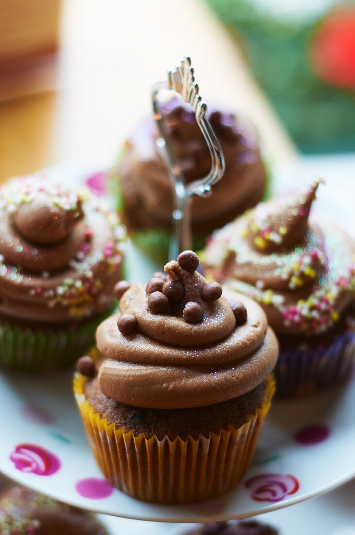 Schokoladen-Cupcakes mit Zuckerperlen auf Etagere