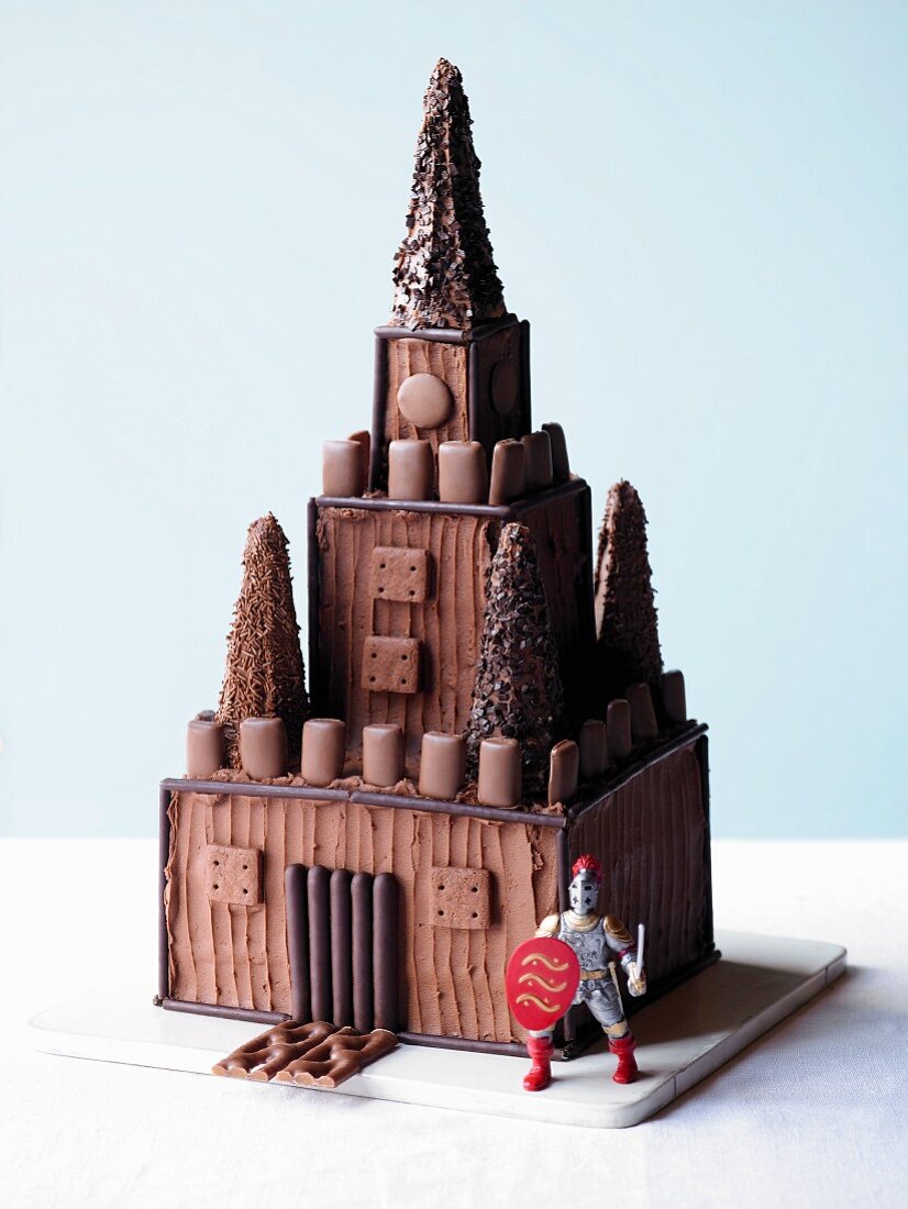 A cake designed to look like a knight's castle, with a knight figurine