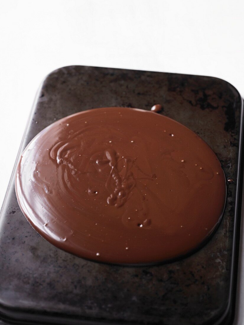 Melted chocolate for making chocolate curls, on a baking tray