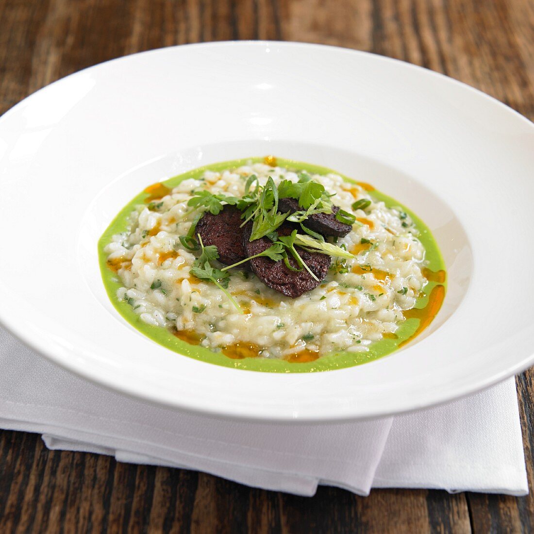 Vialone Nano Risotto with Boudin Noir (Blood Sausage) in a White Bowl