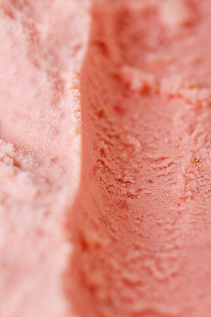 Track left by an ice cream scoop in fresh home-made strawberry ice cream