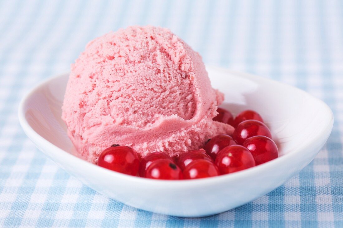 A scoop of home-made redcurrant ice cream with redcurrants