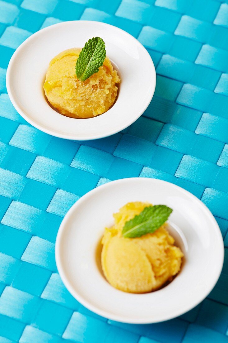 Two scoops of home-made mango sorbet with fresh mint