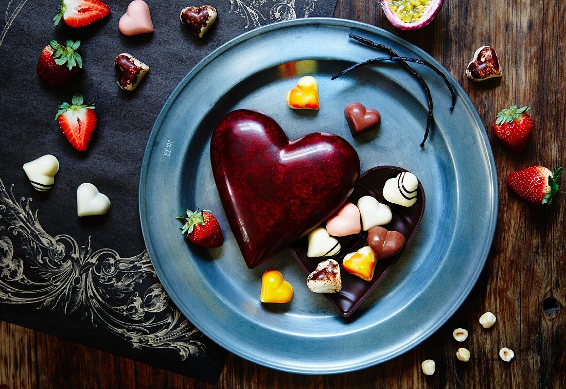 Herzpralinen mit herzförmiger Pralinenschachtel und Erdbeeren
