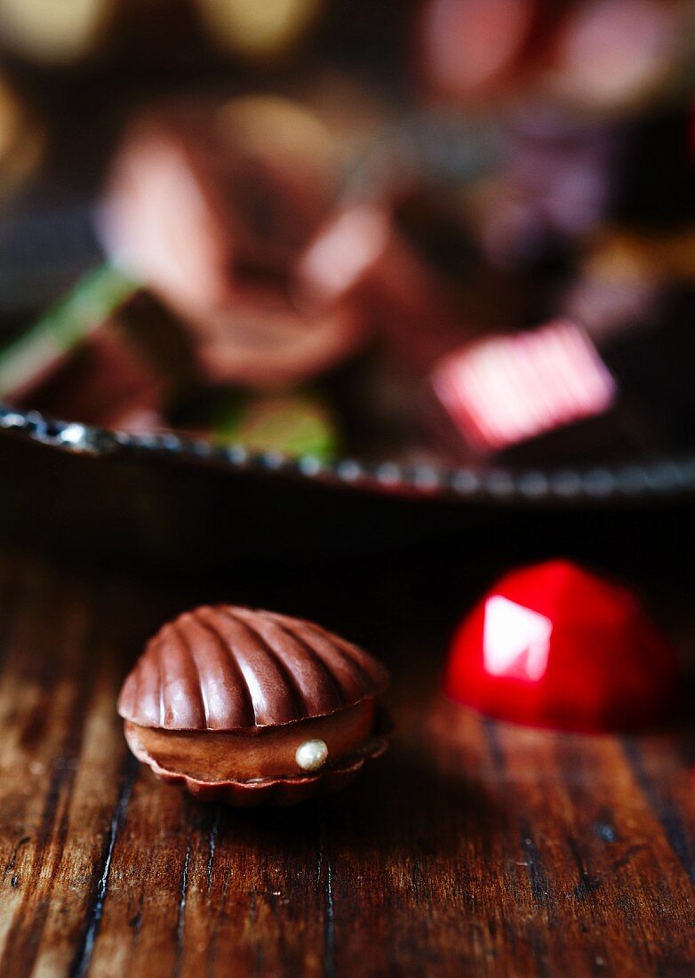 Schokoladenauster vor verschiedenen Pralinen