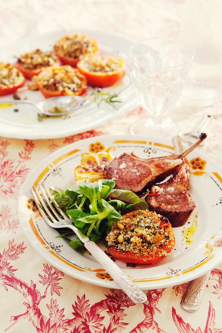 Lamb chops with stuffed tomatoes à la provençale served with lambs lettuce