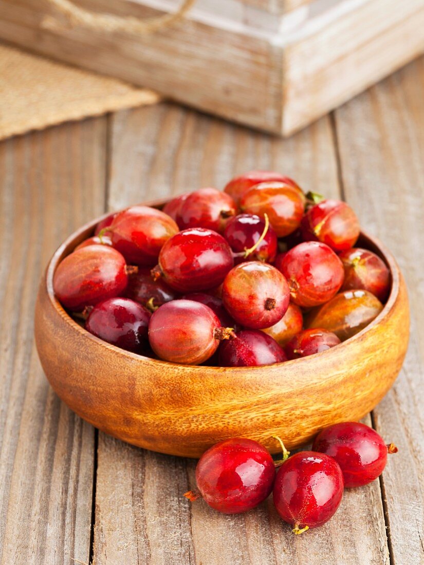 Red gooseberries in a wooden bowl