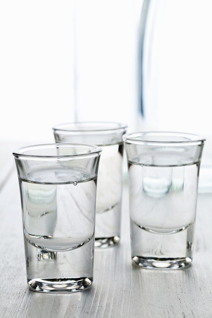 Drei Gläser Anisschnaps (Ouzo) mit Wasserkaraffe