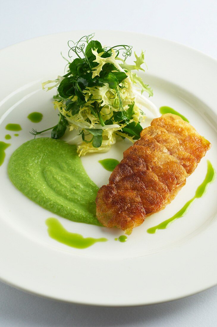 Fried sea bass fillet with pea purée and a side salad