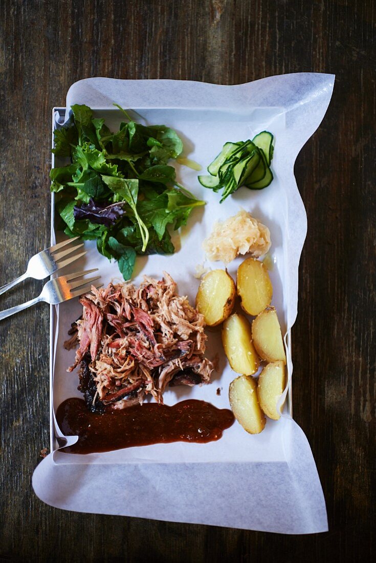 Barbecued pork with salad leaves and potatoes