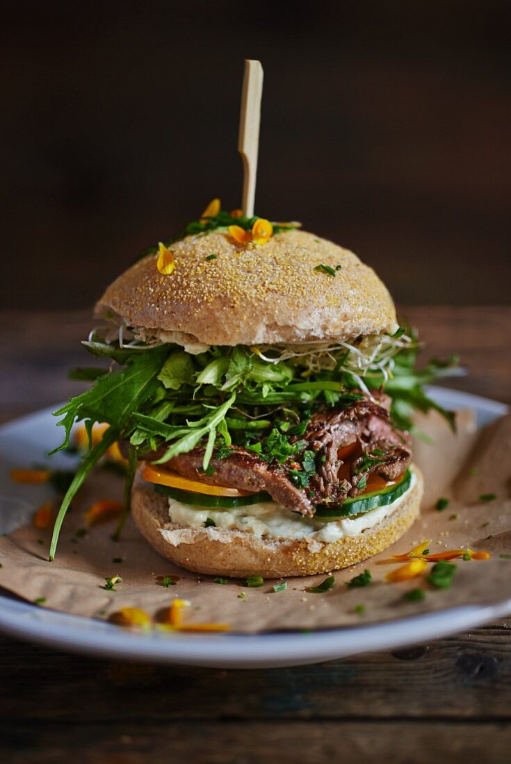 A burger bun filled with beef and rocket