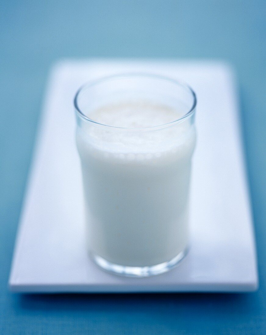 A glass of milk on a white serving platter