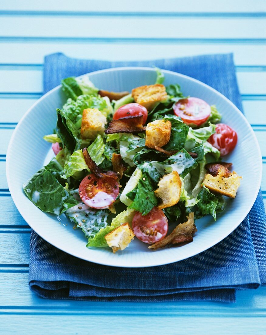 Romaine lettuce with cherry tomatoes, bacon and croutons