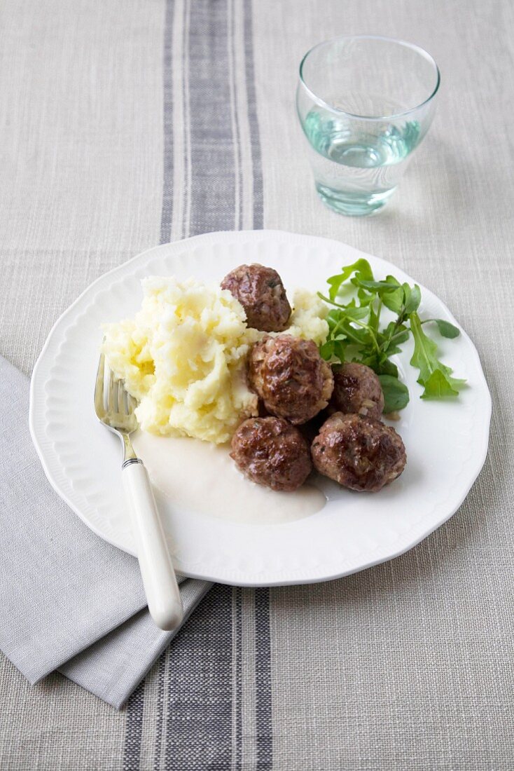 Meatballs with a pale sauce and mashed potato