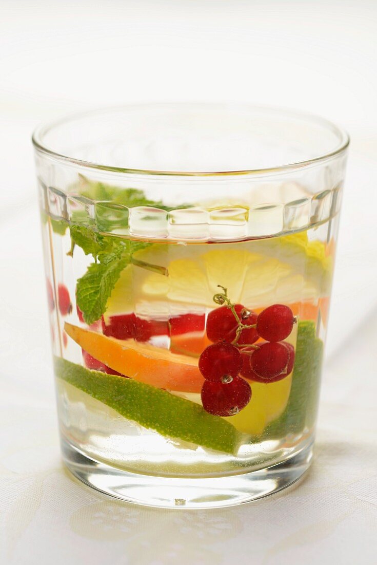 Fruchtiger Drink mit frischen Aprikosen, Johannisbeeren, Limetten und Zitronenmelisse
